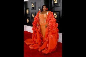 Grammys 2023: Lizzo Makes Grand Entrance at the Red Carpet in Orange Dress and Hooded Cape Adorned With Flowers (Watch Video)